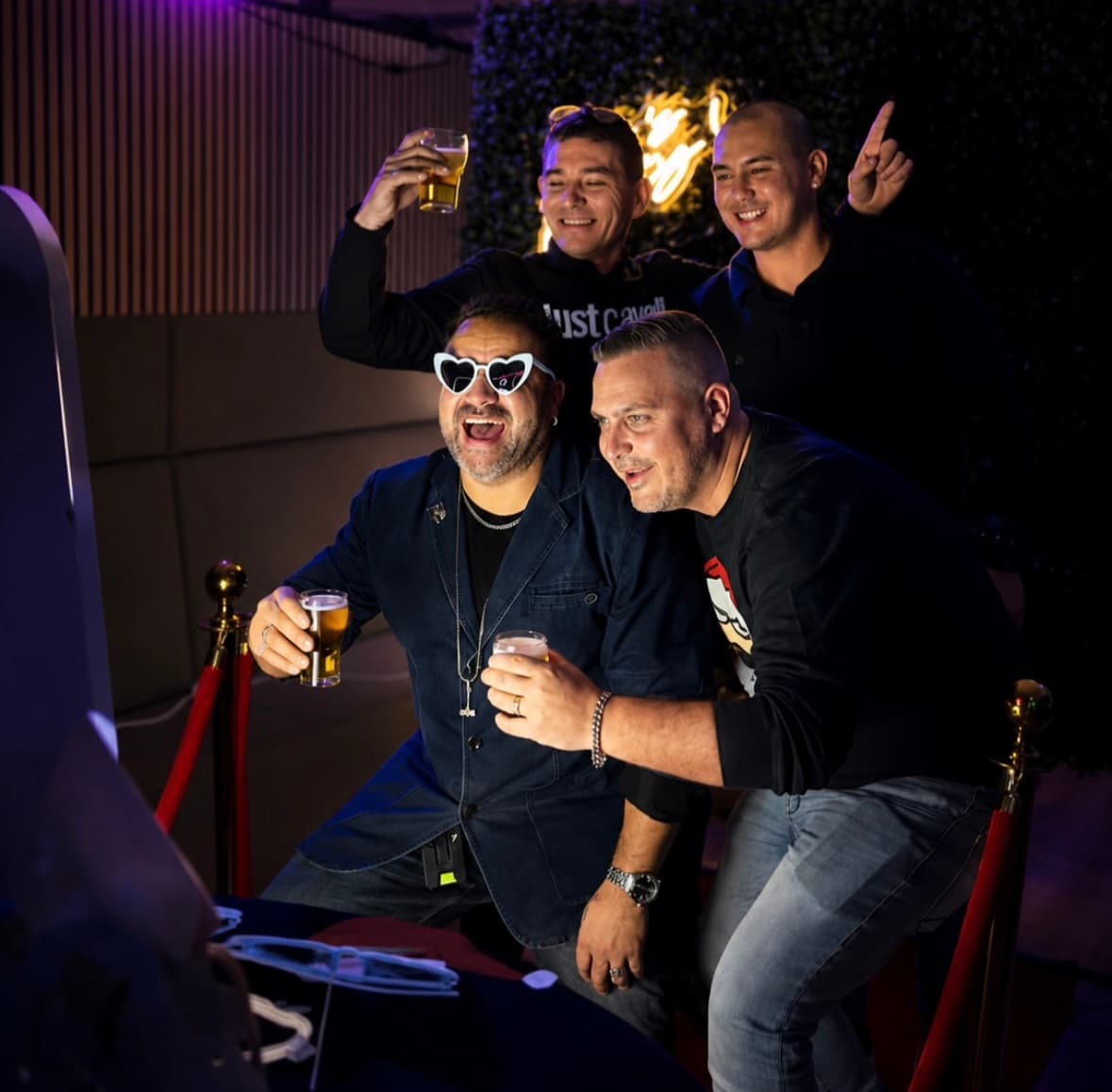 Vier gasten lachen samen voor de Norella Mirror Photobooth tijdens een feest