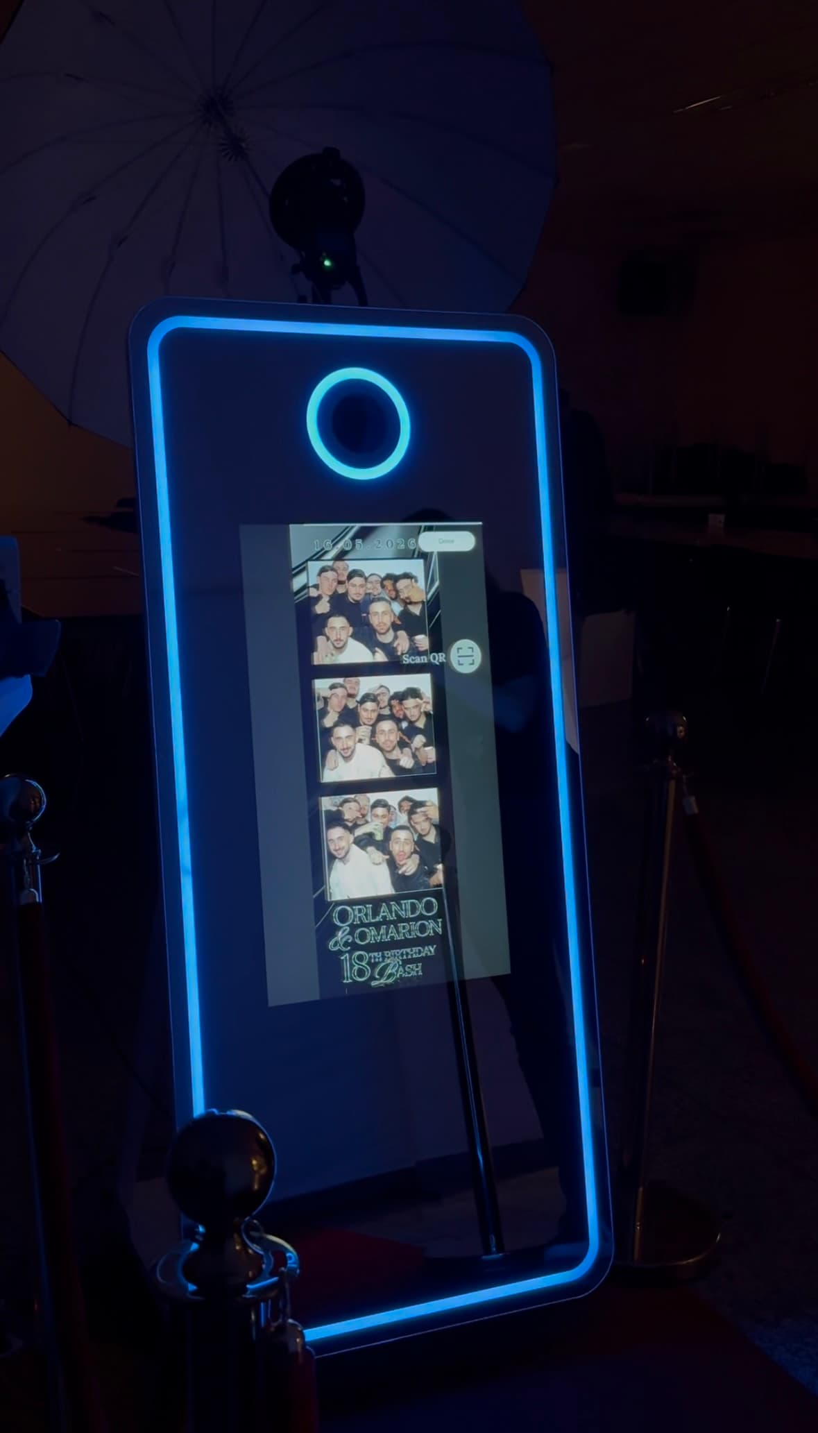 Mirror Photobooth met blauwe verlichting en een gemaakte fotostrip op het scherm
