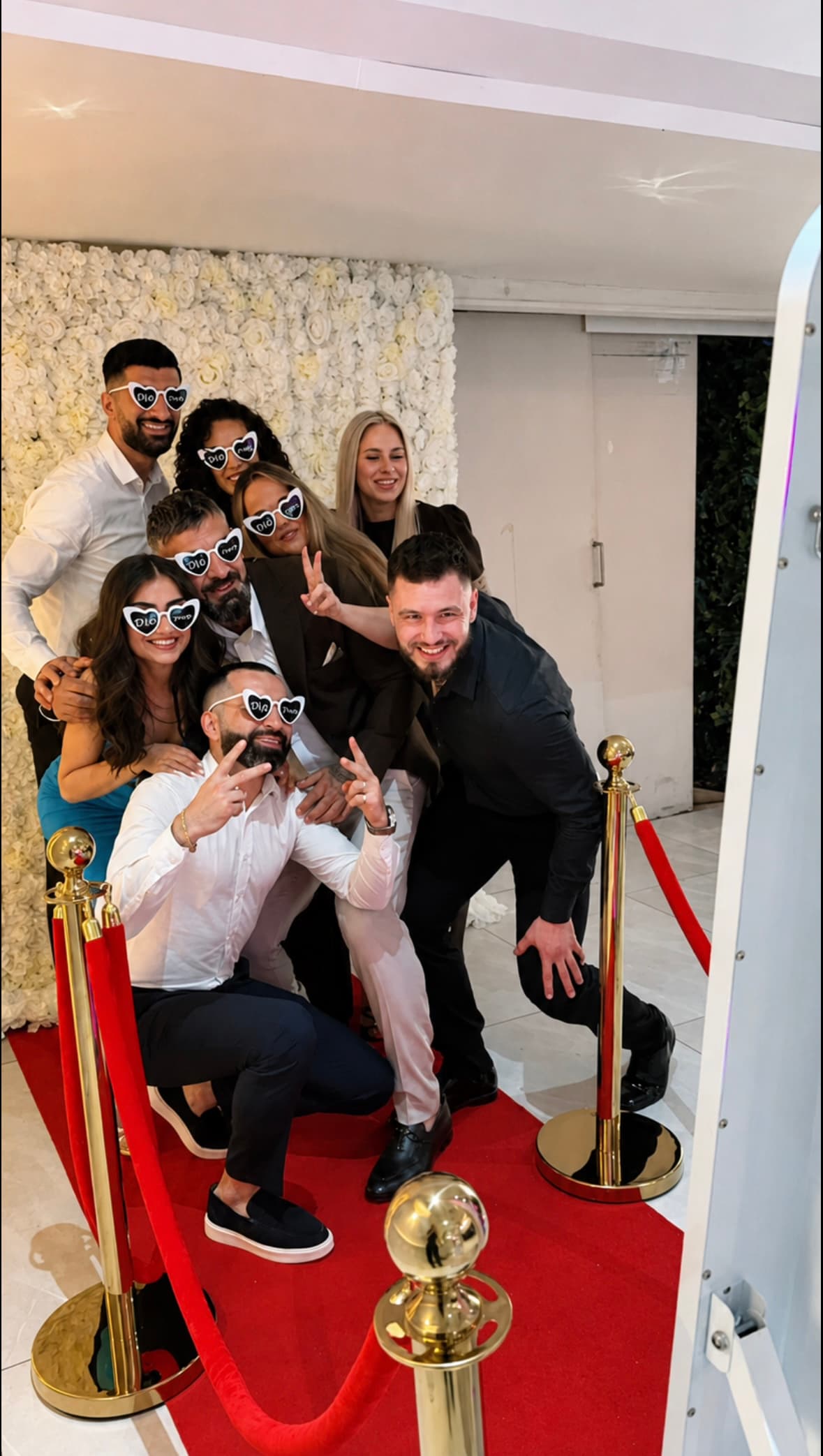 Bruiloftsgasten poseren met gepersonaliseerde hartjesbrillen bij de Mirror Photobooth