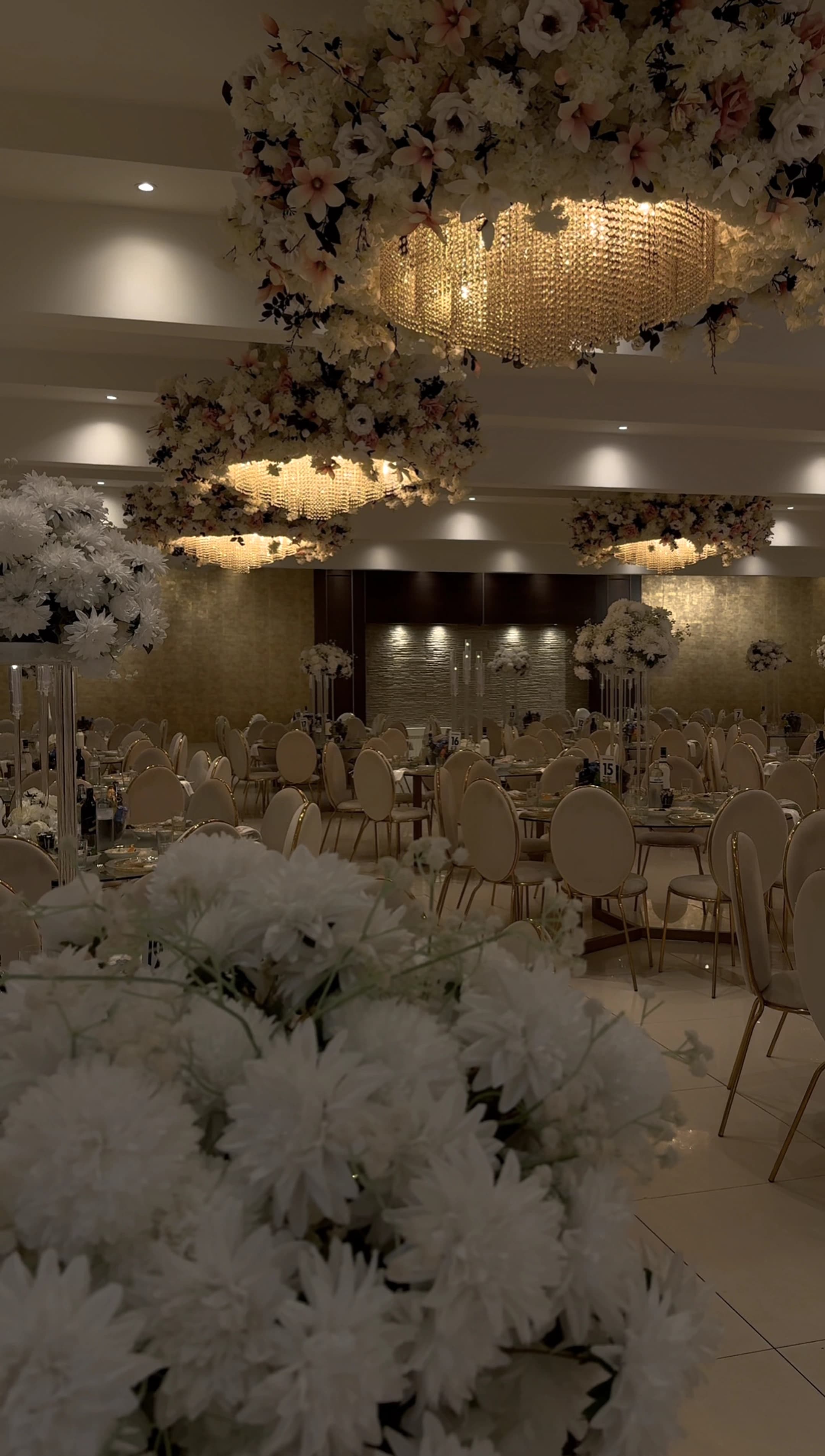 Luxe trouwzaal met bloemrijke kroonluchters en gedekte tafels