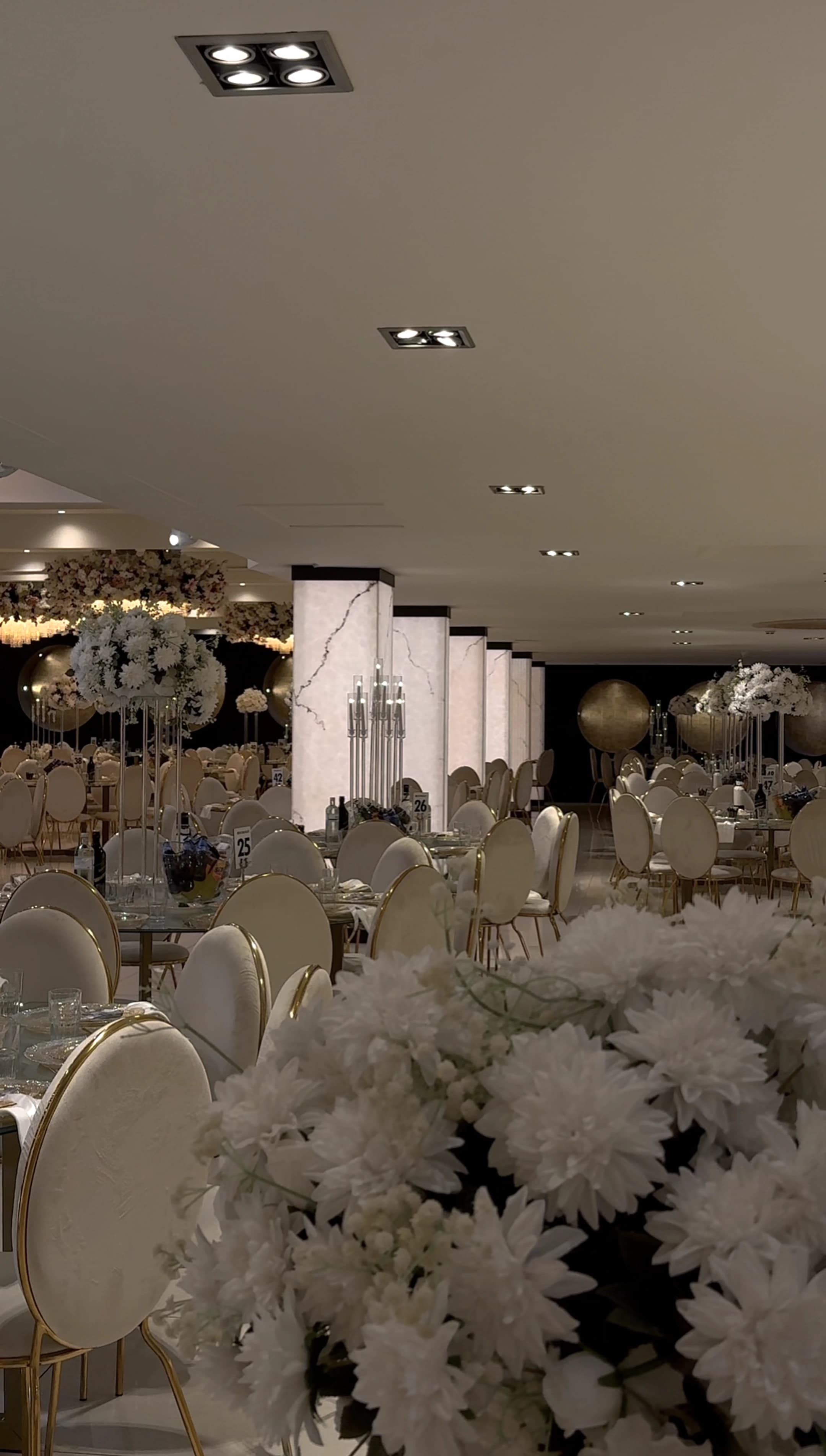 Stijlvol gedekte feestzaal met witte bloemen en gouden accenten