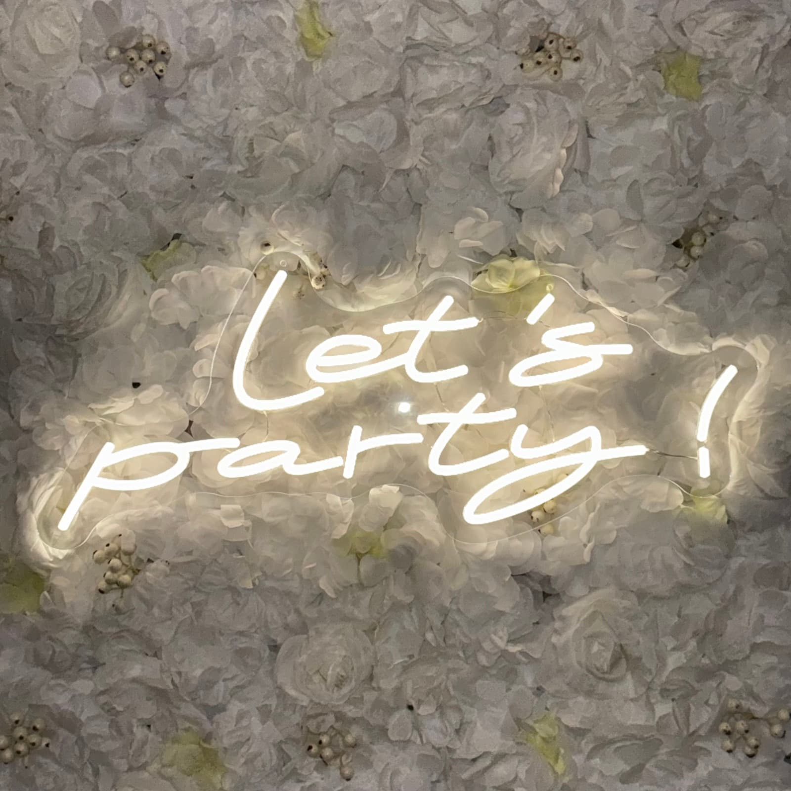 Neon led sign Let's party op witte flowerwall